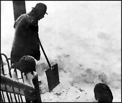 Edna's father shoveling snow from the front steps.