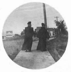 Edna's mother and her friend walking down a boardwalk.